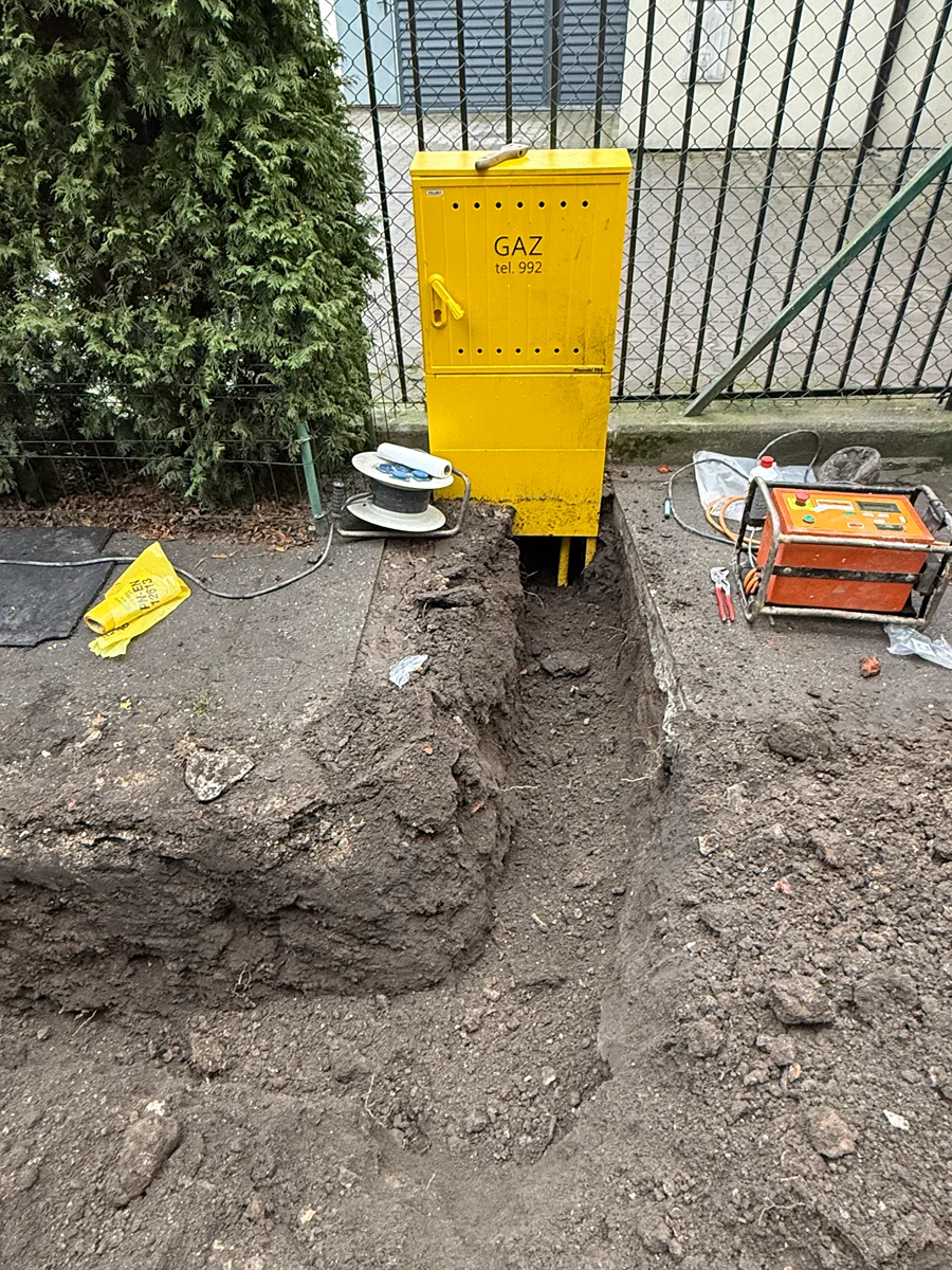 Budowa przyłącza gazowego — żółta rura gazowa w wykopie